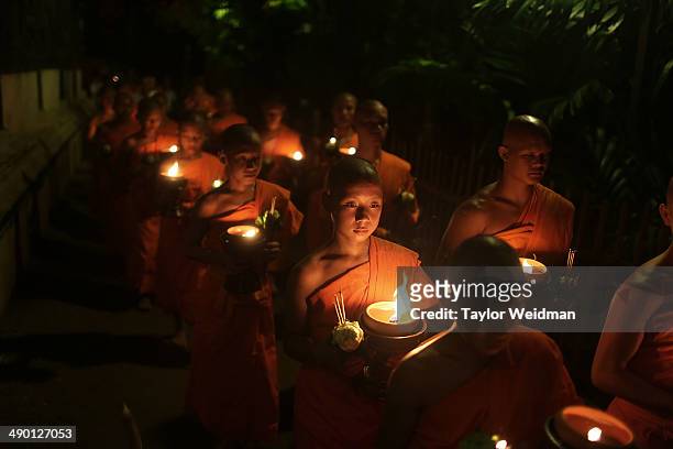 Thai monks at Wat Pan Tao lead a procession three times around the temple in a ceremony celebrating Visak Day on May 13, 2014 in Chiang Mai,...