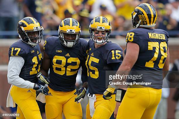 Amara Darboh of the Michigan Wolverines celebrates his four yard touchdown reception against the Brigham Young Cougars with teammates Freddy Canteen,...