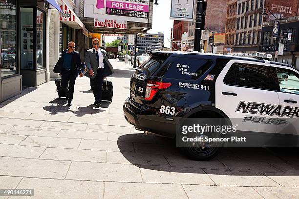 People walk by a police car in downtown on May 13, 2014 in Newark, New Jersey. Voters in New Jersey's largest city go to the polls on May 13, to...