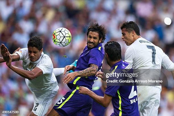 Cristiano Ronaldo of Real Madrid CF heads the ball behind Miguel Torres and Marcos Angeleri , both of Malaga CF and his teammate of Real madrid...