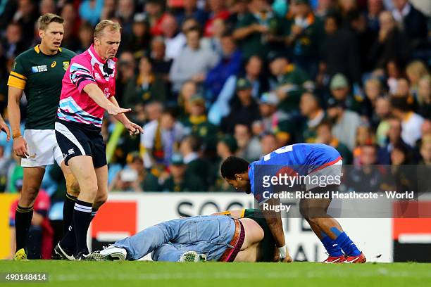 Referee Wayne Barnes looks on as a pitch invader enters the field of play during the 2015 Rugby World Cup Pool B match between South Africa and Samoa...