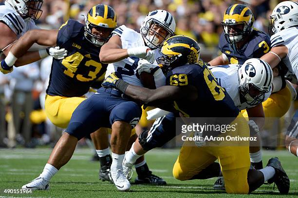 Francis Bernard of the Brigham Young Cougars is stopped by Willie Henry of the Michigan Wolverines during the second half of the Wolverines' 31-0...