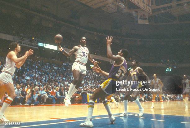 Darryl Dawkins of the Philadelphia 76ers goes up to shoot over Magic Johnson of the Los Angeles Lakers during an NBA basketball game circa 1980 at...