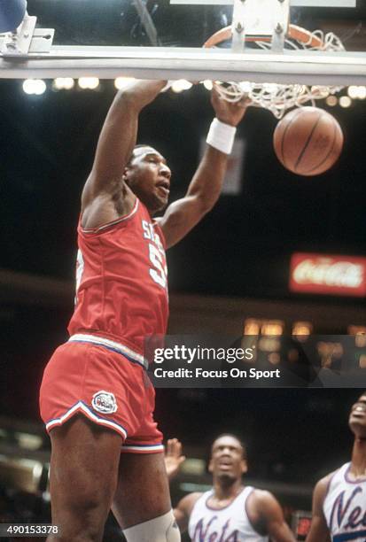 Darryl Dawkins of the Philadelphia 76ers slam dunks the ball against the New Jersey Nets during an NBA basketball game circa 1981 at the Rutgers...