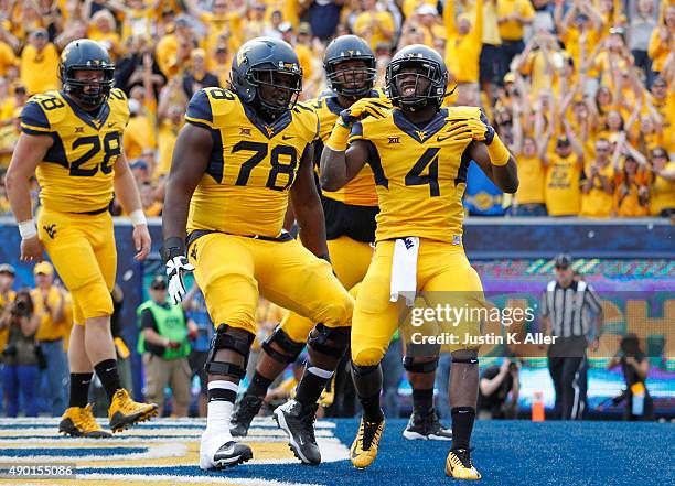 Wendell Smallwood of the West Virginia Mountaineers celebrates with teammates after rushing for a 4 yard touchdown in the first quarter during the...