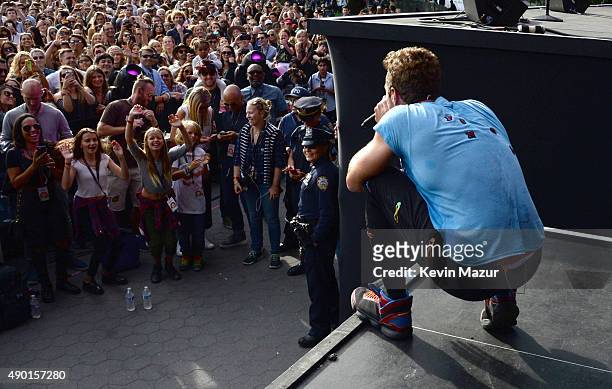 Chris Martin performs with Coldplay onstage while Apple Martin and Moses Martin watch from the crowd during 2015 Global Citizen Festival to end...