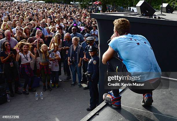 Chris Martin performs with Coldplay onstage while Apple Martin and Moses Martin watch from the crowd during 2015 Global Citizen Festival to end...