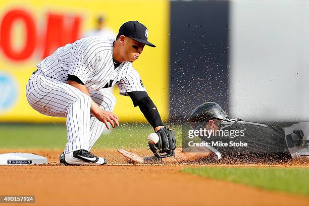 Robert Refsnyder of the New York Yankees is unable to handle the throw as Adam Eaton of the Chicago White Sox steals second base in the first inning...