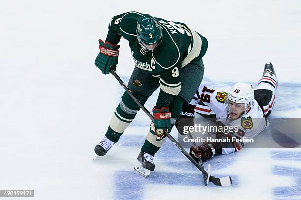 Mikko Koivu of the Minnesota Wild controls the puck against Jonathan Toews of the Chicago Blackhawks in Game Three of the Second Round of the 2014...