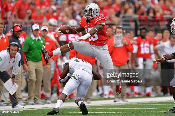 Ezekiel Elliott of the Ohio State Buckeyes leaps over Darius Phillips of the Western Michigan Broncos for a first down gain in the second quarter at...