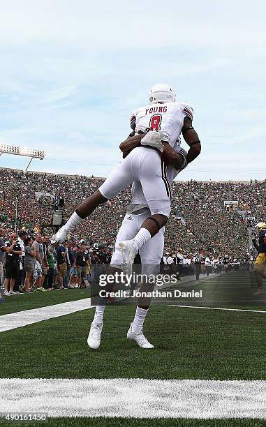 Marquis Young of the Massachusetts Minutemen is lifted by teammate Tajae Sharpe after scoring a touchdown against the Notre Dame Fighting Irish at...