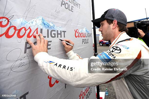 Daniel Suarez, driver of the ARRIS Toyota, signs the Coors Light Pole Award backdrop after qualifying on pole position for the NASCAR Xfinity Series...