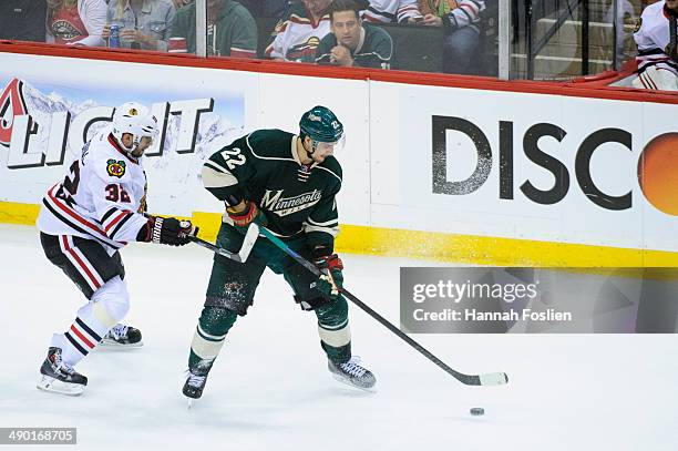 Nino Niederreiter of the Minnesota Wild controls the puck against Michal Rozsival of the Chicago Blackhawks in Game Four of the Second Round of the...