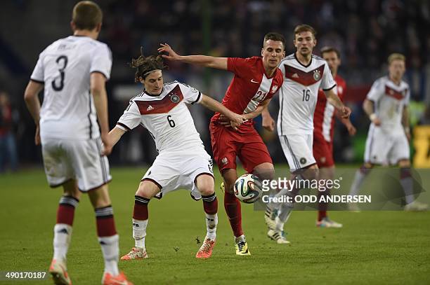 Germany's midfielder Sebastian Rudy vies with Poland's striker Arkadiusz Milik during the FIFA 2014 World Cup friendly football match Germany vs...
