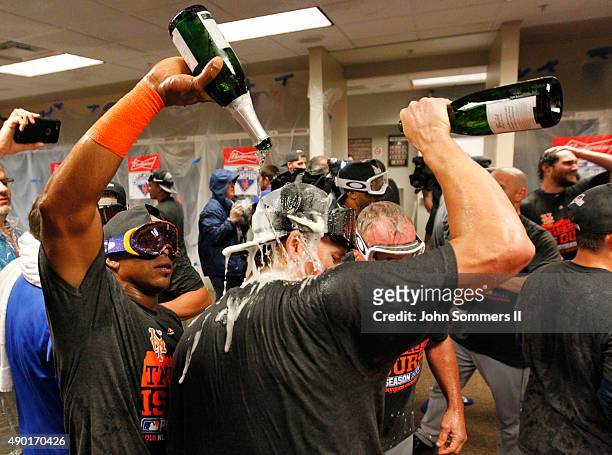 Yoenis Cespedes of the New York Mets sprays champagne as they celebrate in the clubhouse after defeating the Cincinnati Reds 10-2 to clinch the...