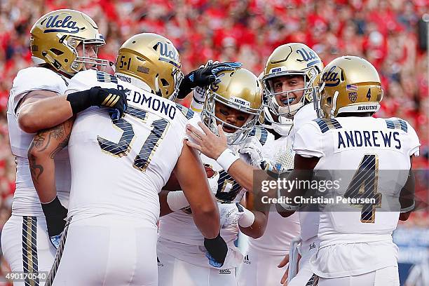 Wide receiver Thomas Duarte of the UCLA Bruins is congratulad by quarterback Josh Rosen and teammates after catching a 35 yard touchdown reception...