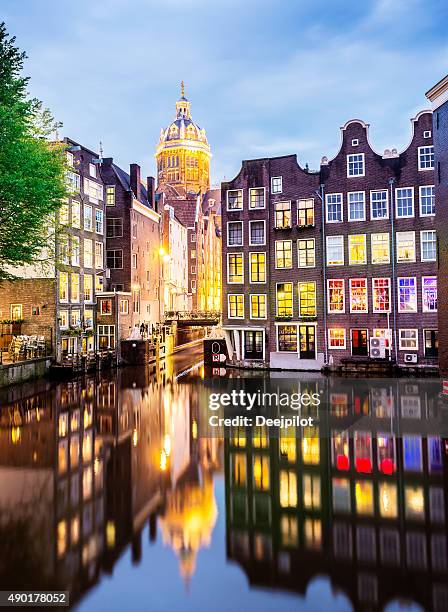 st nicholas church with reflection in amsterdam canal netherlands - amsterdam canals stockfoto's en -beelden