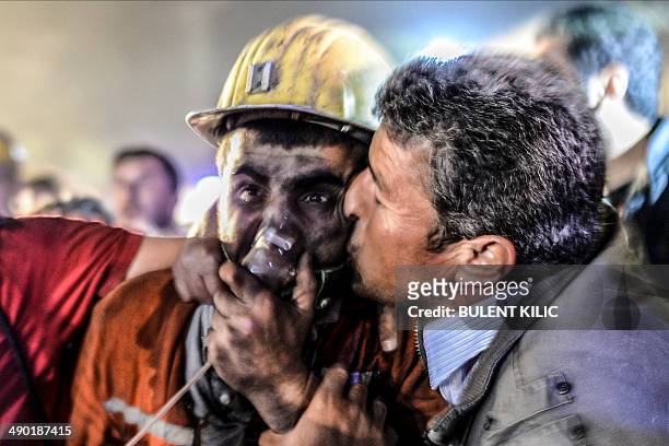 Man kisses his son, rescued of the mine, on May 13, 2014 after an explosion in a coal mine in Manisa. At least 157 miners were killed in collapsed...