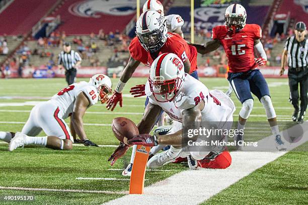 Tight end Jaylen Samuels of the North Carolina State Wolfpack leaps for the end zone in front of cornerback Jeremy Reaves of the South Alabama...