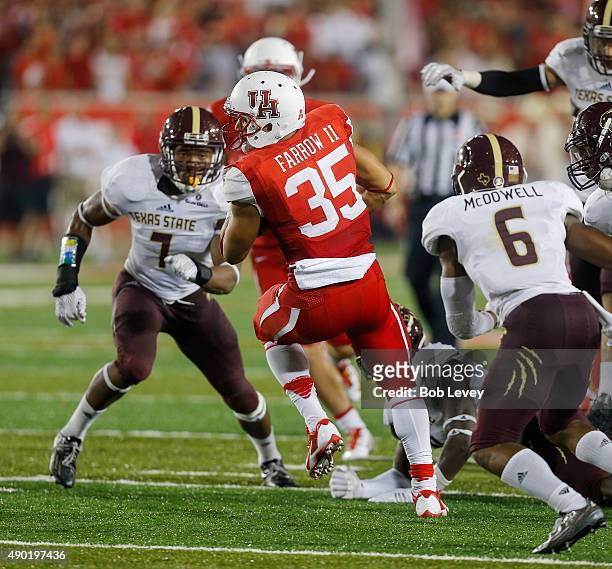 Kenneth Farrow of the Houston Cougars breaks a tackle as he rushes against the Texas State Bobcats as Easy Anyama of the Texas State Bobcats and...