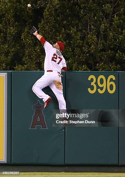 Center fielder Mike Trout of the Los Angeles Angels of Anaheim jumps at the wall and makes the catch to take a home away from Jesus Montero of the...