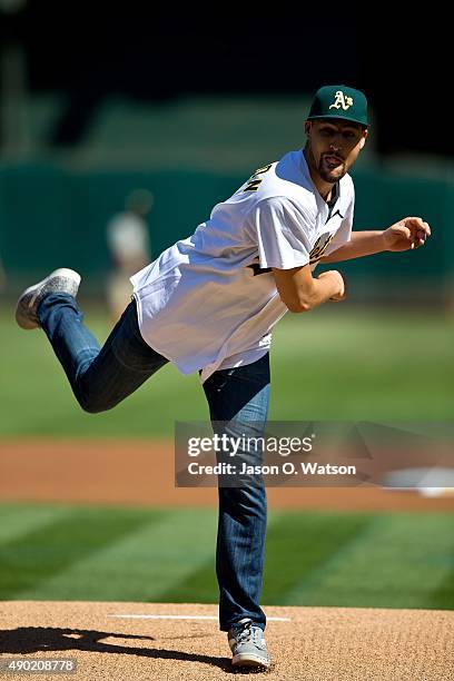 Basketball player Klay Thompson of the Golden State Warriors throws out a ceremonial first pitch before the game between the Oakland Athletics and...