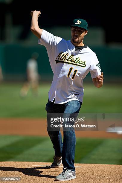 Basketball player Klay Thompson of the Golden State Warriors throws out a ceremonial first pitch before the game between the Oakland Athletics and...