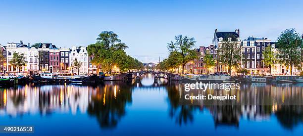 puentes y canales de amsterdam, holland iluminado al atardecer - estrecho descripción física fotografías e imágenes de stock