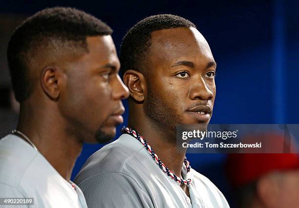 Domonic Brown of the Philadelphia Phillies and John Mayberry Jr. #15 look on from the dugout during MLB game action against the Toronto Blue Jays on...