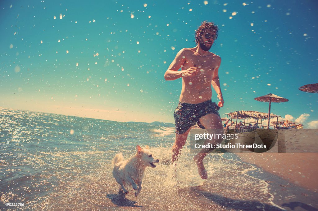 Man running with his dog on the beach