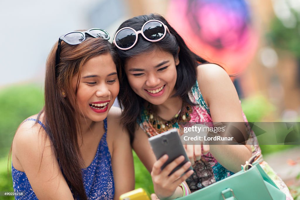Two young women having fun using a smartphone