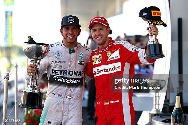 Lewis Hamilton of Great Britain and Mercedes GP celebrates on the podium next to Sebastian Vettel of Germany and Ferrari after winning the Formula...