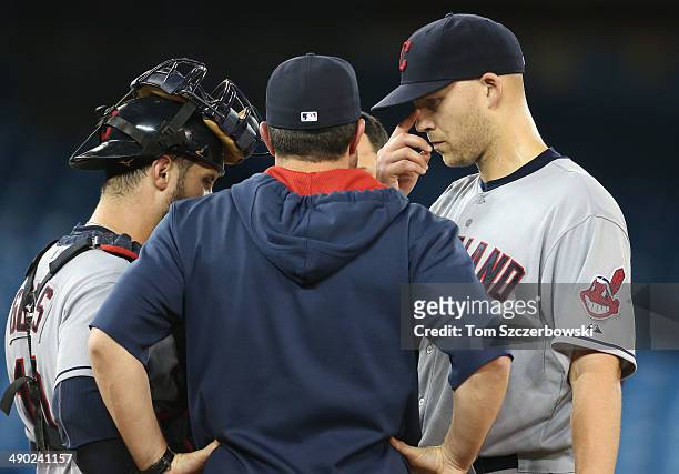 Justin Masterson of the Cleveland Indians and Yan Gomes look on as pitching coach Mickey Callaway talks to Masterson on the mound in the sixth inning...