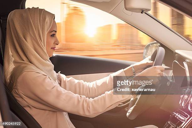 emirati frau fahren ein auto in dubai - arab driving stock-fotos und bilder