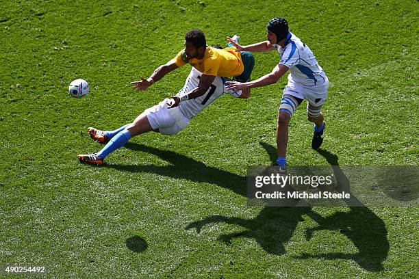 Henry Speight of Australia passes the ball as he is tackled by Rodrigo Silva and Matias Beer of Uruguay during the 2015 Rugby World Cup Pool A match...