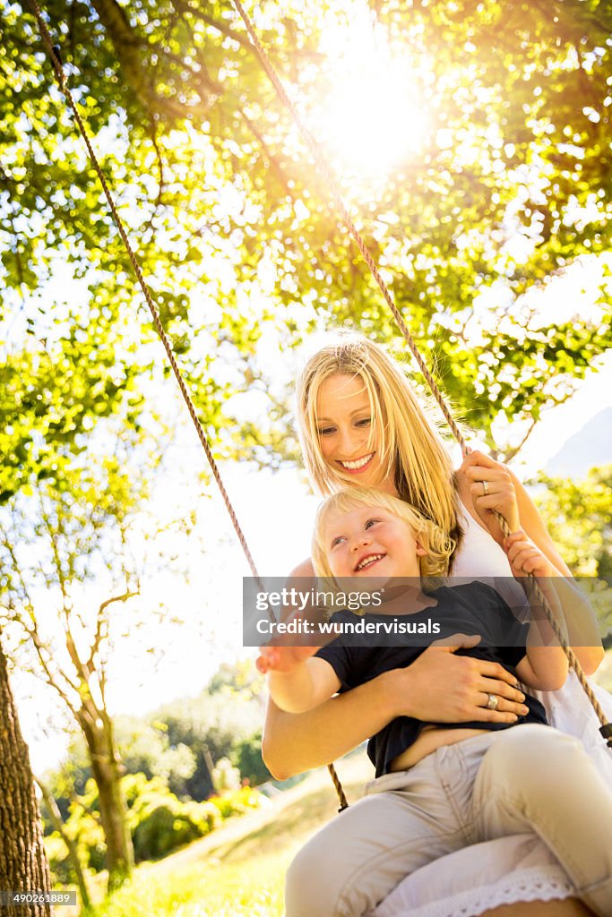 Mom and son on swing in park