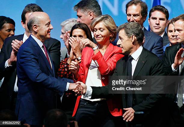 Head of French right-wing party 'Les Republicains' and former President Nicolas Sarkozy shakes hands with 'Les Republicains' member and Mayor of...