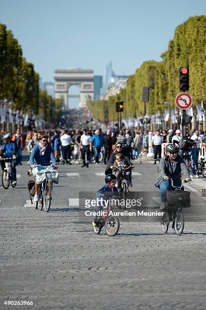 Families riding their bikes avenue des Champs-Elysees with the Arc de Triomphe in the background during the car free day on September 27, 2015 in...