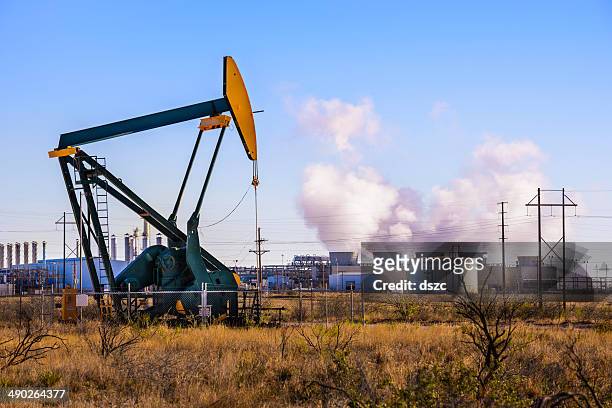 pumpjack (oil derrick) and refinery power plant in west texas - west texas stock pictures, royalty-free photos & images