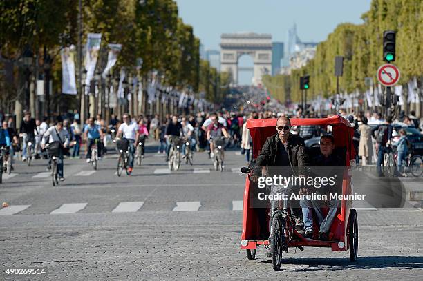 Man is driving a Tuk-Tuk cab on the Champs Elysees during the car free day on September 27, 2015 in Paris, France. Today between 11am to 6pm Central...