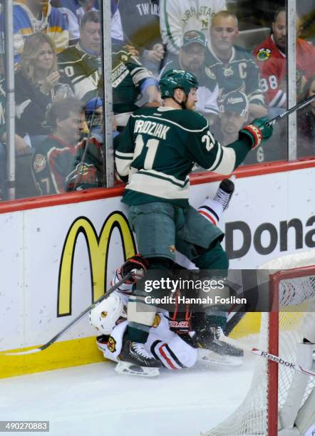 Kyle Brodziak of the Minnesota Wild checks Sheldon Brookbank of the Chicago Blackhawks into the boards during the third period in Game Six of the...