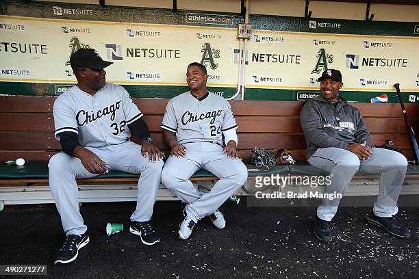 Coach Daryl Boston, Dayan Viciedo, and coach Harold Baines of the Chicago White Sox get ready in the dugout before the game against the Oakland...