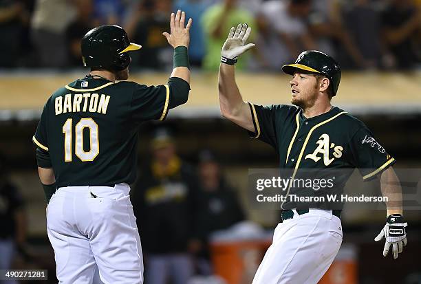 Brandon Moss and Daric Barton of the Oakland Athletics celebrates after Moss hit a two-run homer in the bottom of the eighth inning against the...