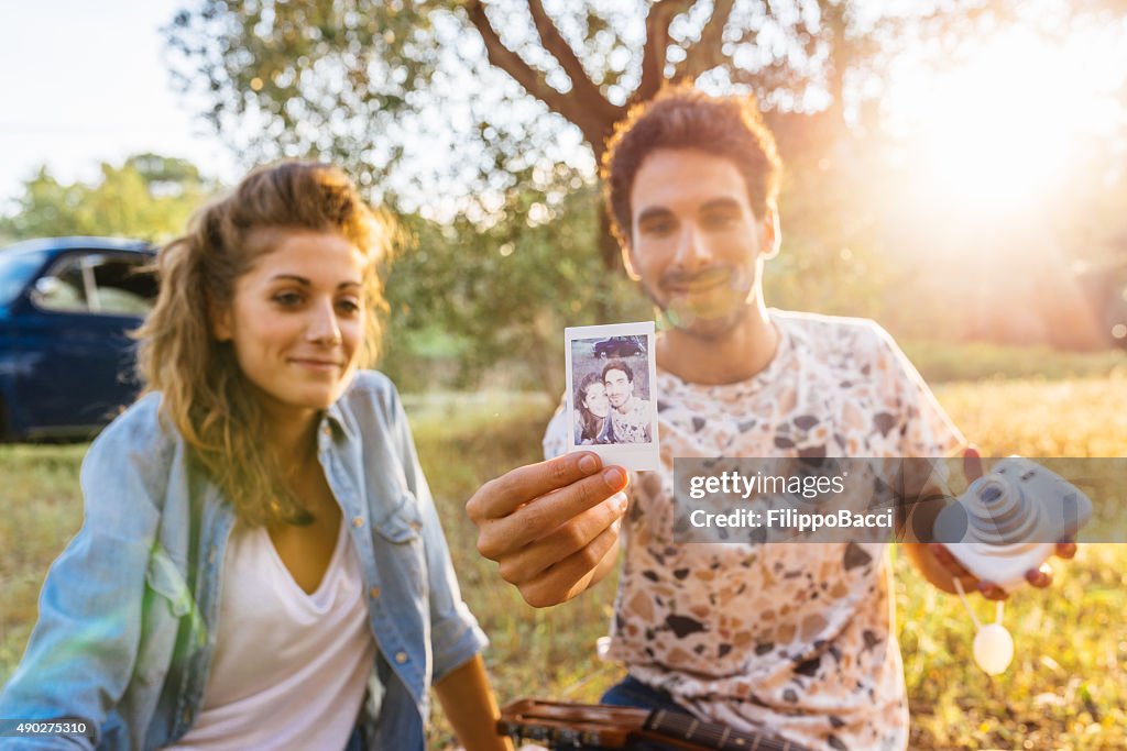 Young Couple Showing A Vintage Selfie Photo