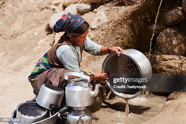 tibetan woman washing dishes. mustang - lo manthang stock pictures, royalty-free photos & images