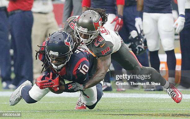 DeAndre Hopkins of the Houston Texans is tackled by Tim Jennings of the Tampa Bay Buccaneers in the first quarter on September 27, 2015 at NRG...
