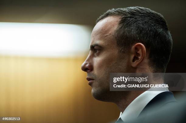 South African Paralympic sprinter Oscar Pistorius stands in the accused dock as he listens to Judge Thokozile Masipa dock during his murder trial at...