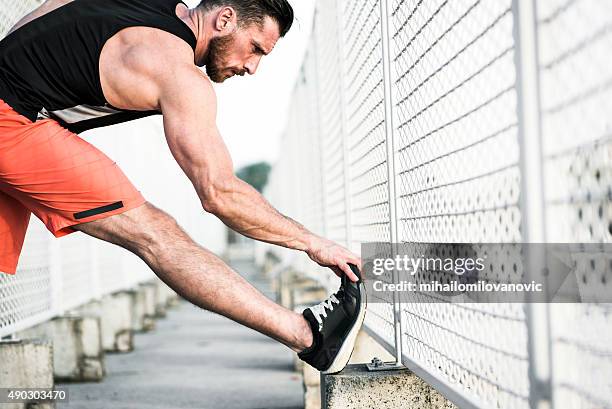 stretching after workout - injured street stockfoto's en -beelden