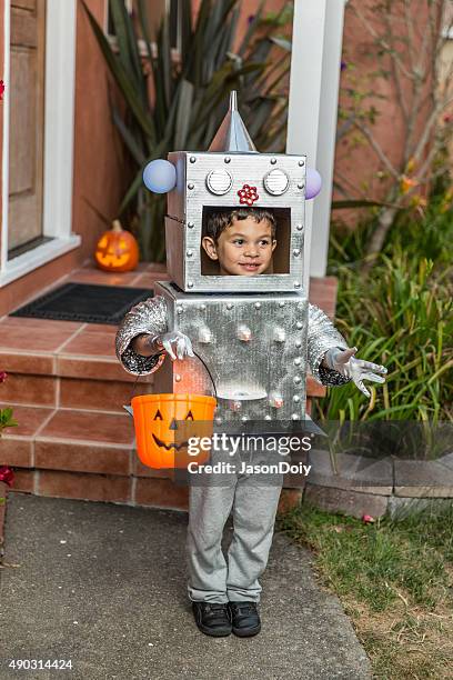 fröhliches halloween: kleine junge roboter mit trick oder behandlung - robot costume stock-fotos und bilder