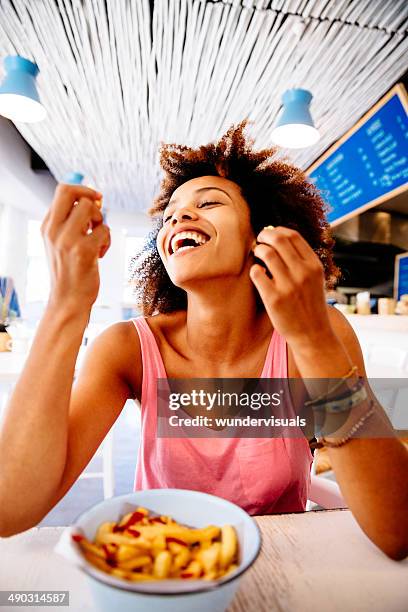 girl eating french fries in restaurant - happy snacking stock pictures, royalty-free photos & images